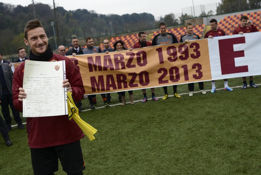 Roma, 28 marzo 2013: il capitano della Roma Francesco Totti viene festeggiato nel centro sportivo di Trigoria a Roma dai suoi compagni di squadra nel giorno dei 20 anni dall&#39;esordio in serie A (Ansa)
